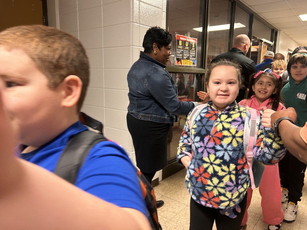 JCPS Flash Dad volunteers do high-fives and fist bumps with students as they walk down the hall.