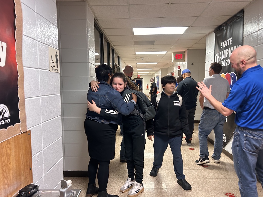 JCPS Flash Dad volunteers do high-fives and fist bumps with students as they walk down the hall.