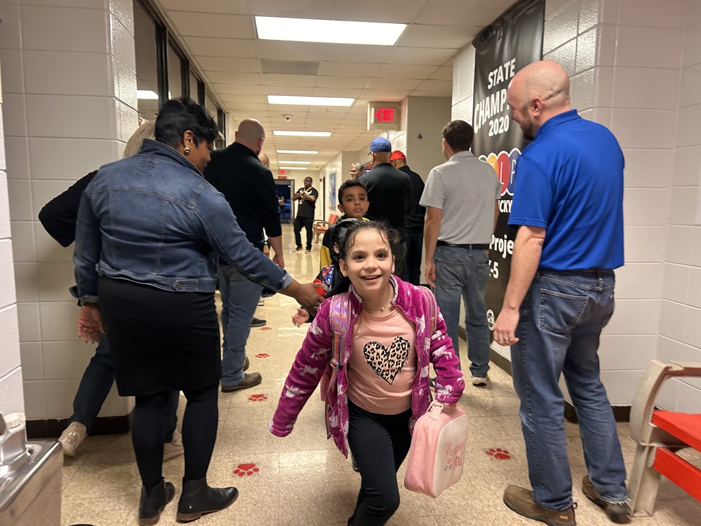 JCPS Flash Dad volunteers do high-fives and fist bumps with students as they walk down the hall.