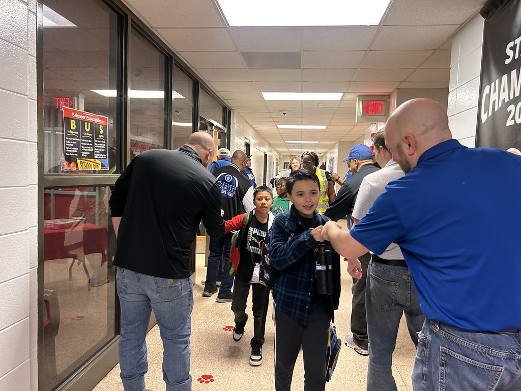 JCPS Flash Dad volunteers do high-fives and fist bumps with students as they walk down the hall.