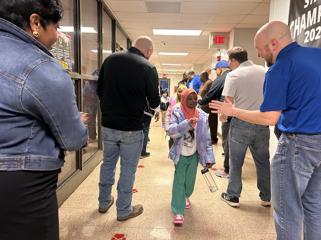 JCPS Flash Dad volunteers do high-fives and fist bumps with students as they walk down the hall.