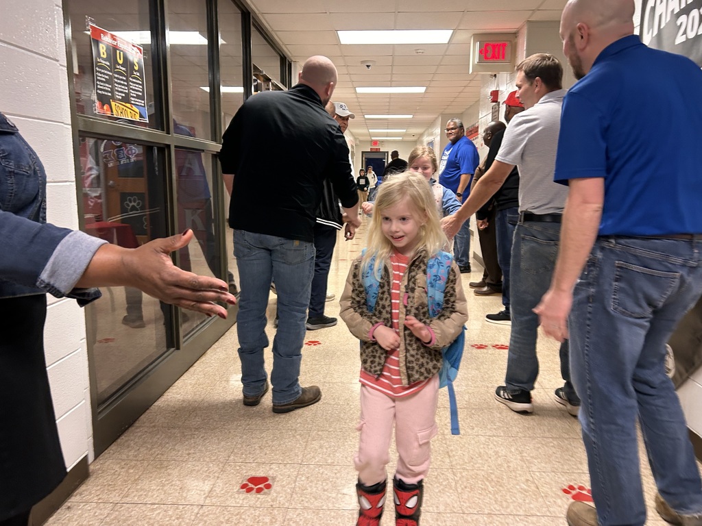 JCPS Flash Dad volunteers do high-fives and fist bumps with students as they walk down the hall.