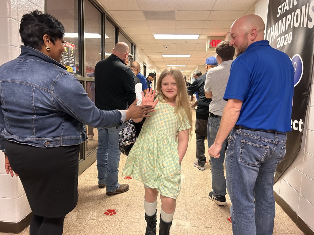 JCPS Flash Dad volunteers do high-fives and fist bumps with students as they walk down the hall.
