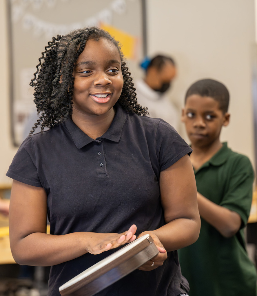 A student hits a drum.