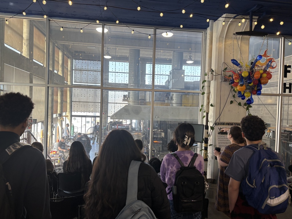 students standing in glass center watching live demos