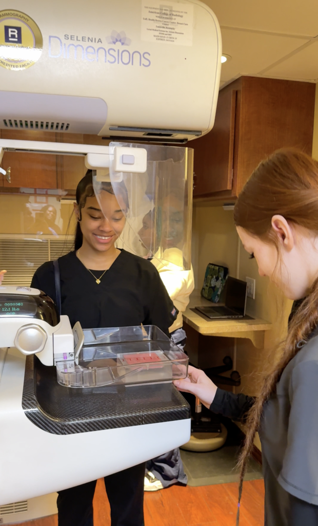 Students look at a mammography machine.