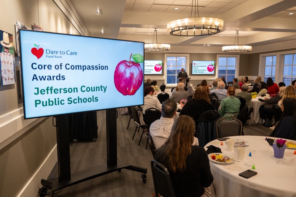 A sign says "Dare to Care Food Bank, Core of Compassion Awards, Jefferson County Public Schools."