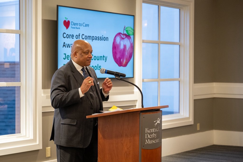 Dr. Yearwood stands at a podium and smiles.