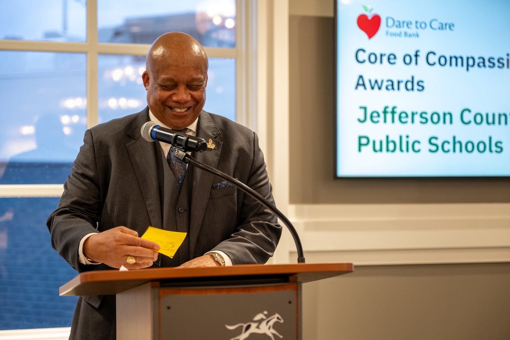 Dr. Yearwood stands at a podium and smiles.