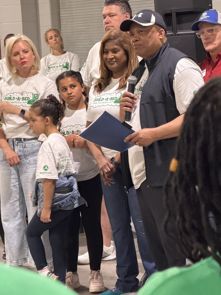Dr. Yearwood speaks into a microphone while others stand nearby.