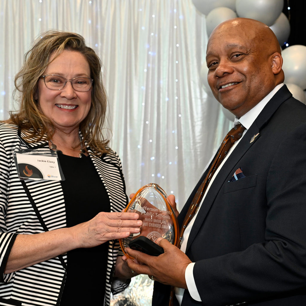 Superintendent Dr. Brian Yearwood accepts an award from another adult.
