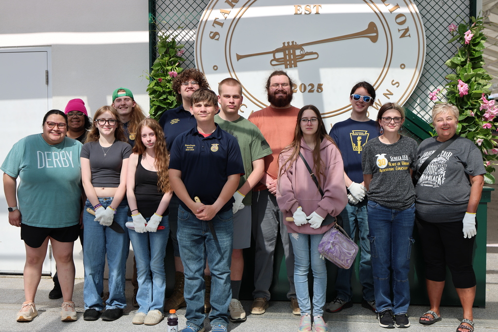 Students and adults pose for a picture and smile.