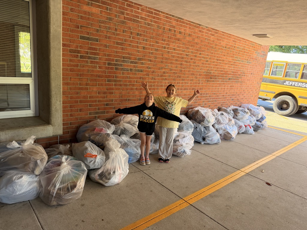 Bowen Elementary students pose for a picture in front of bags of shoe donations.