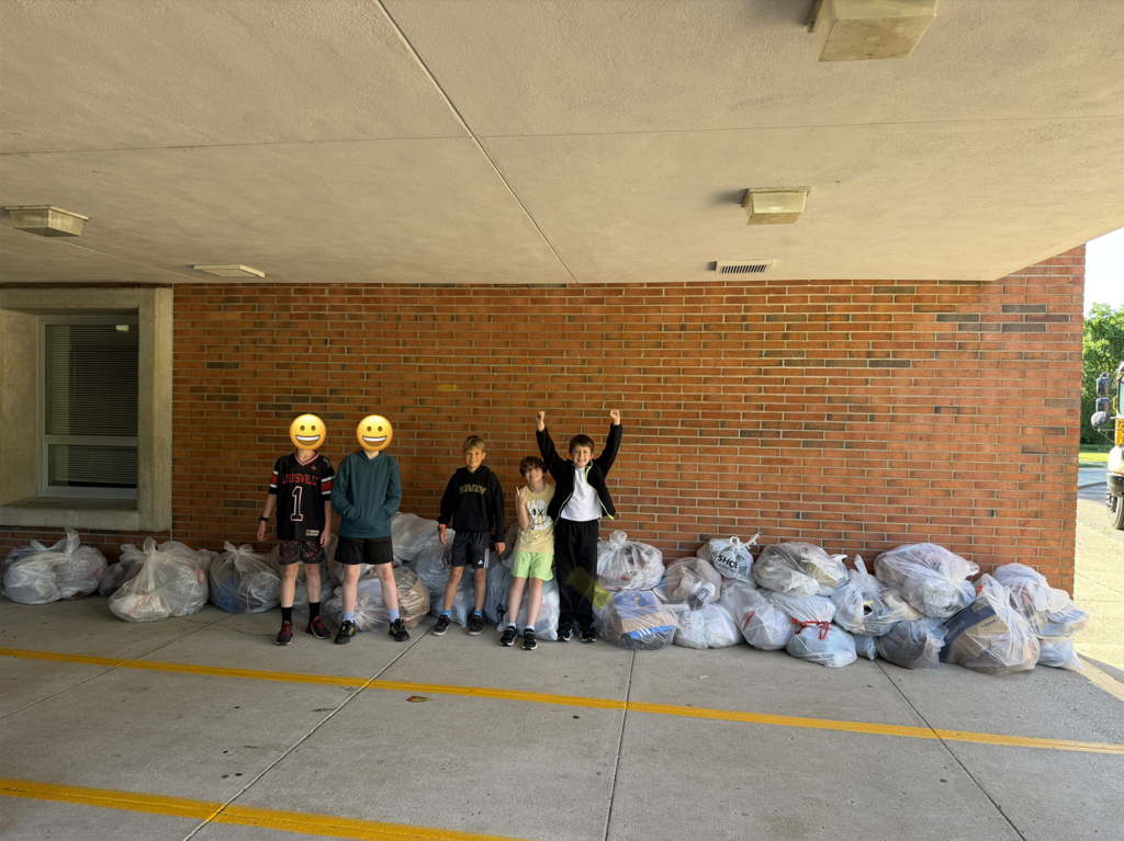 Bowen Elementary students pose for a picture in front of bags of shoe donations.