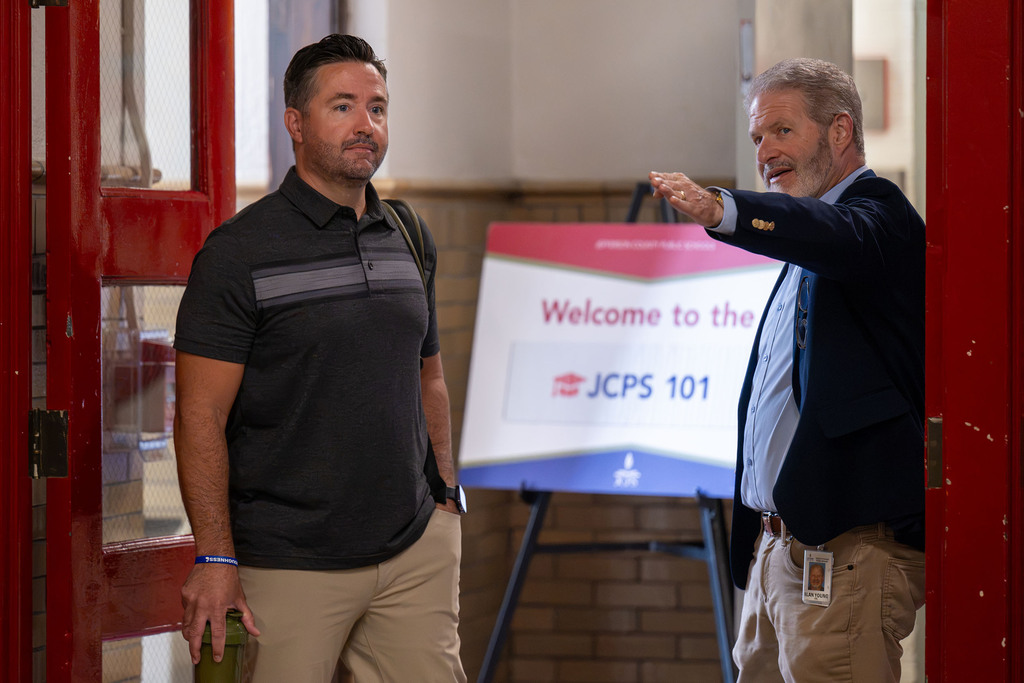 A man directs another man to the JCPS 101 event.
