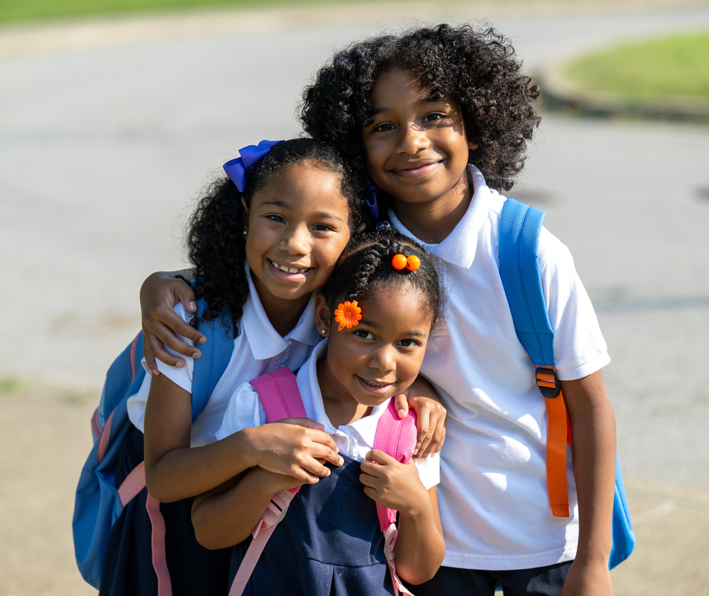 Three student pose for a picture and smile.