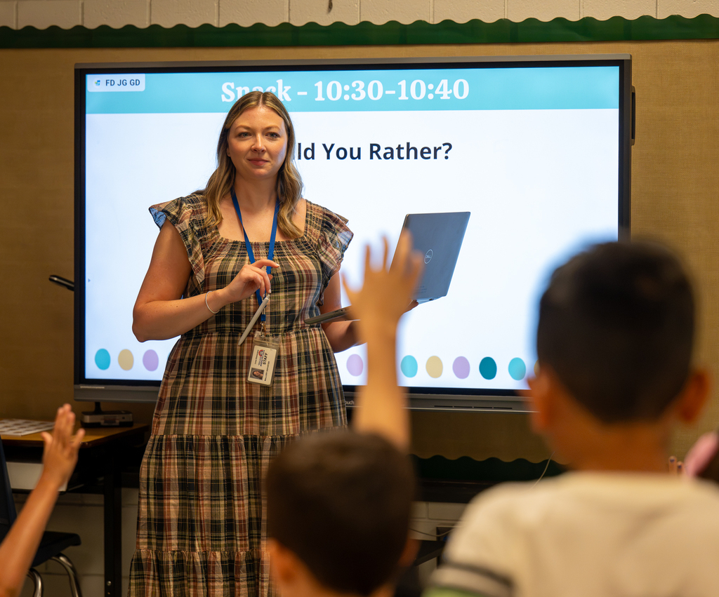 A teacher stands at the front of the classroom.