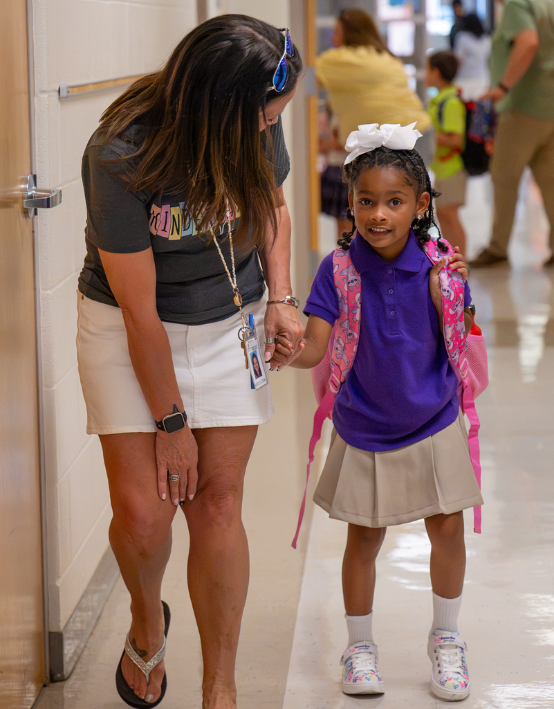 A student walks down the hall with an adult.