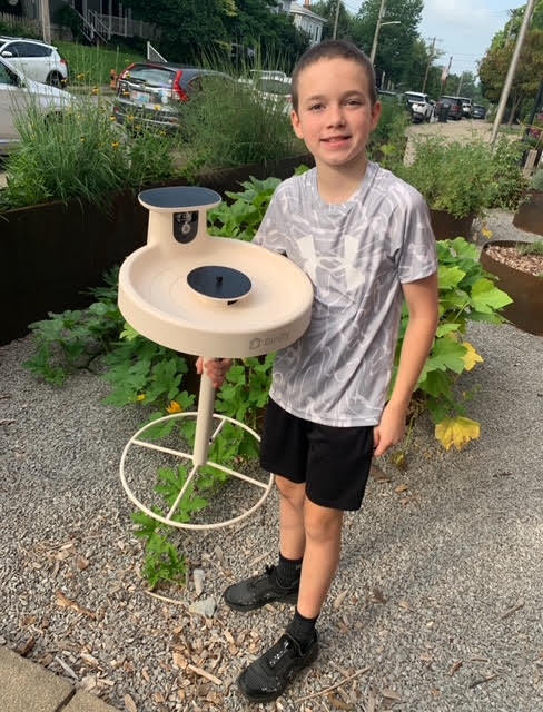 A student holds a bird bath.