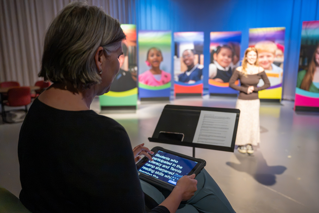 Two video coordinators work with a student to produce the "Our Kids" TV show.