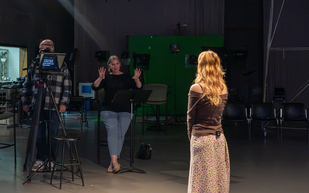 Two video coordinators work with a student to produce the "Our Kids" TV show.