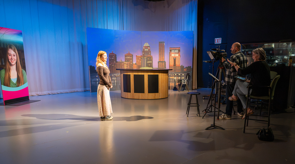 Two video coordinators work with a student to produce the "Our Kids" TV show.