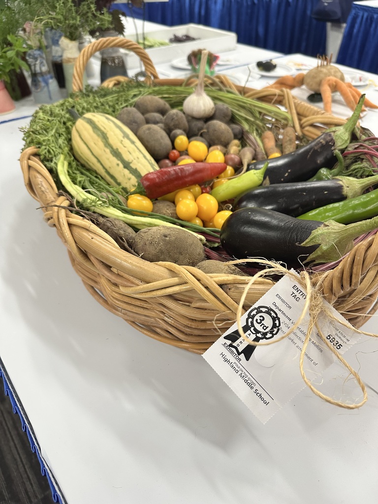 A basket of vegetables sits on a table.