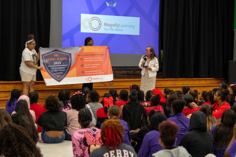 Students holding a banner recognizing their school as a PBL Model School