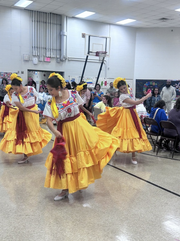 Young women dancing in traditional clothing.