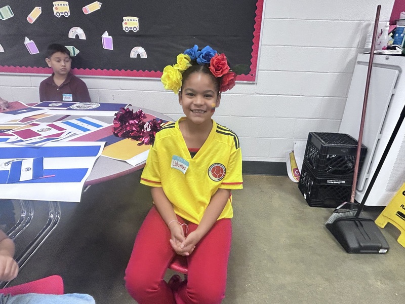 Student in a yellow shirt and flower crown.