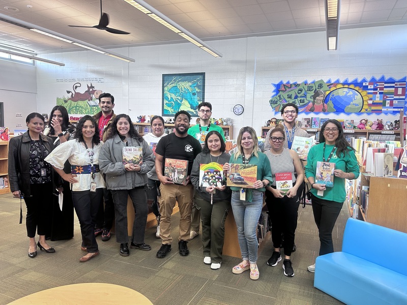 Parents and volunteers holding books to read to students