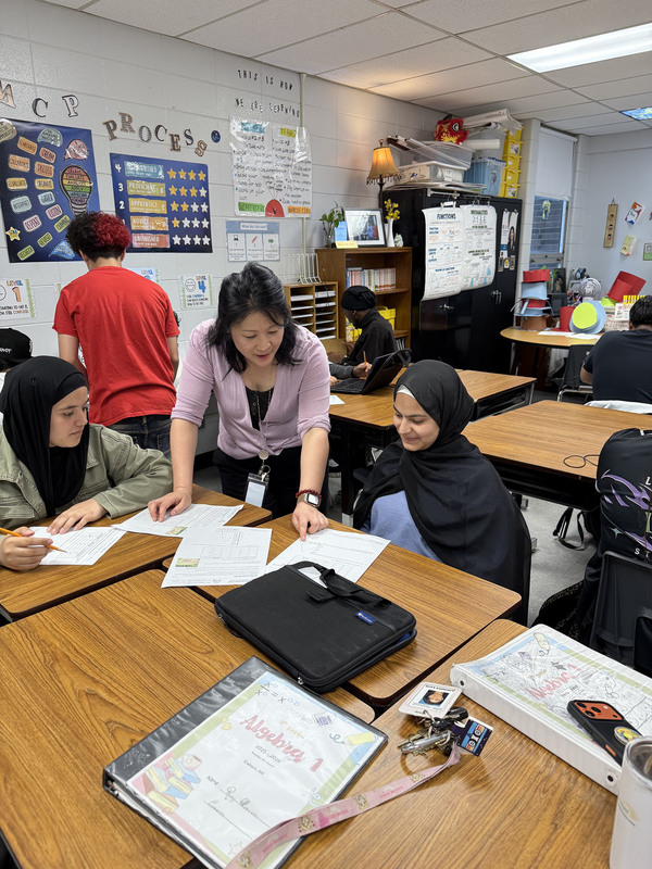 Hui Couch teaches students in a classroom.