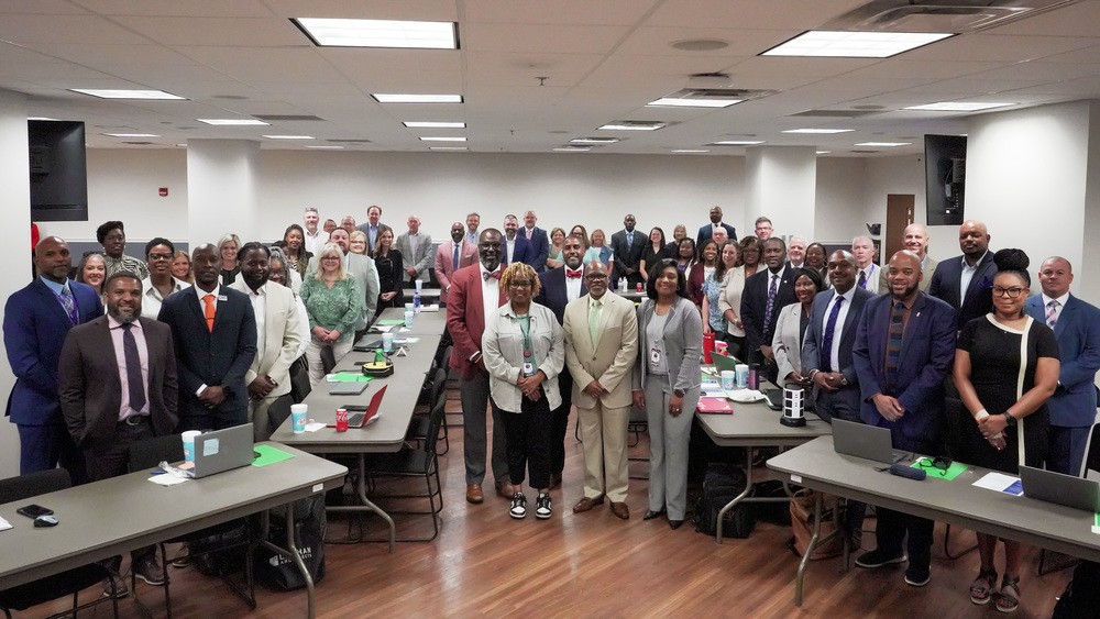 Image shows principals in the Jefferson County School District standing in a room and smiling for a photo.