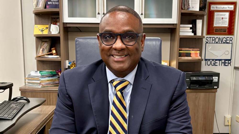 Image is a photo of JEFCOED Superintendent Dr. Walter Gonsoulin smiling while sitting at his desk.