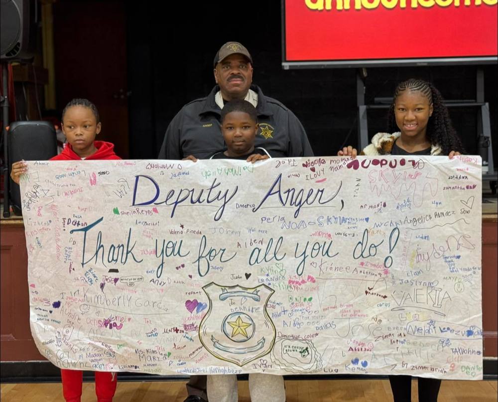 students and deputy holding banner