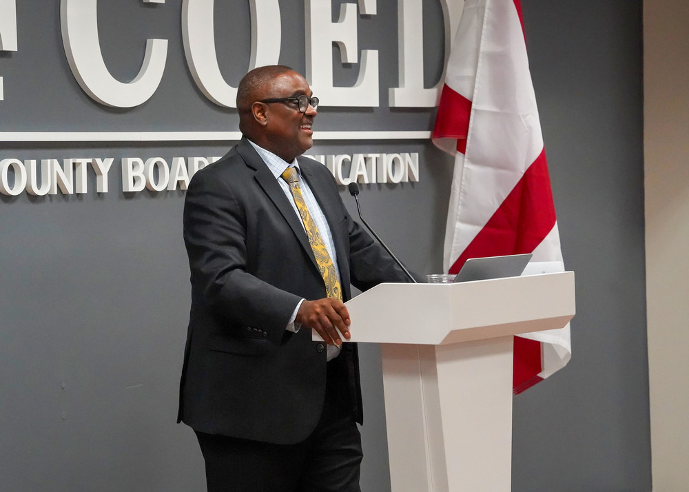 Superintendent Dr. Walter Gonsoulin stands at a podium and speaks during the Jefferson County Schools Mayors Luncheon.
