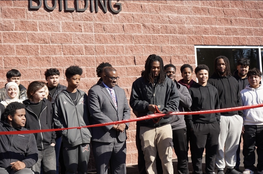 Students and Jefferson County Schools Superintendent stand together outside the new Auto Tech Building at Shades Valley High School for a ribbon cutting ceremony.