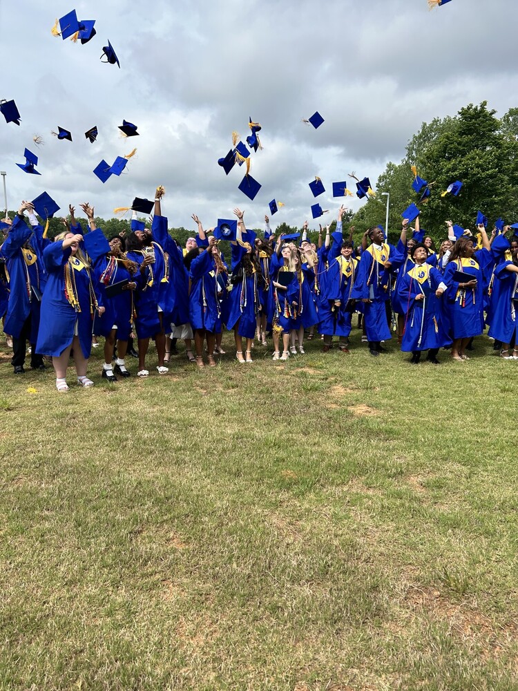 graduates in their gowns tossing caps into the air after graduation