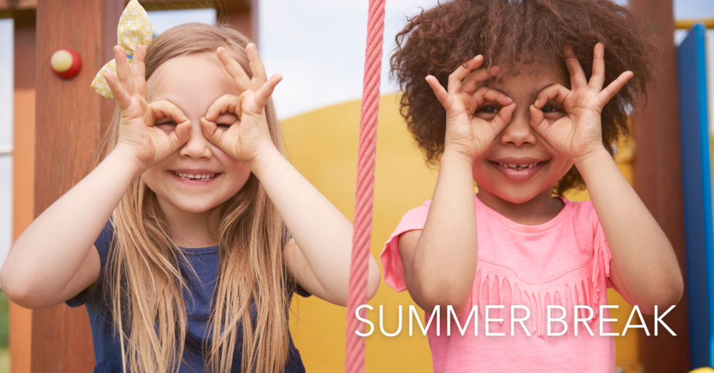 Two girls playing on the playground and looking through their finger like binoculars. Summer Break.