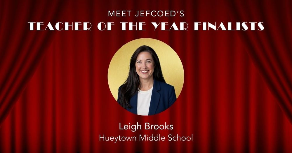 Graphic introduces JEFCOED Teacher of the Year finalist Leigh Brooks from Hueytown Middle School. The graphic has a photo of Brooks with text over a red curtain background. In the photo Brooks wears a navy blue blazer and a white shirt and smiles. She has dark brown hair.