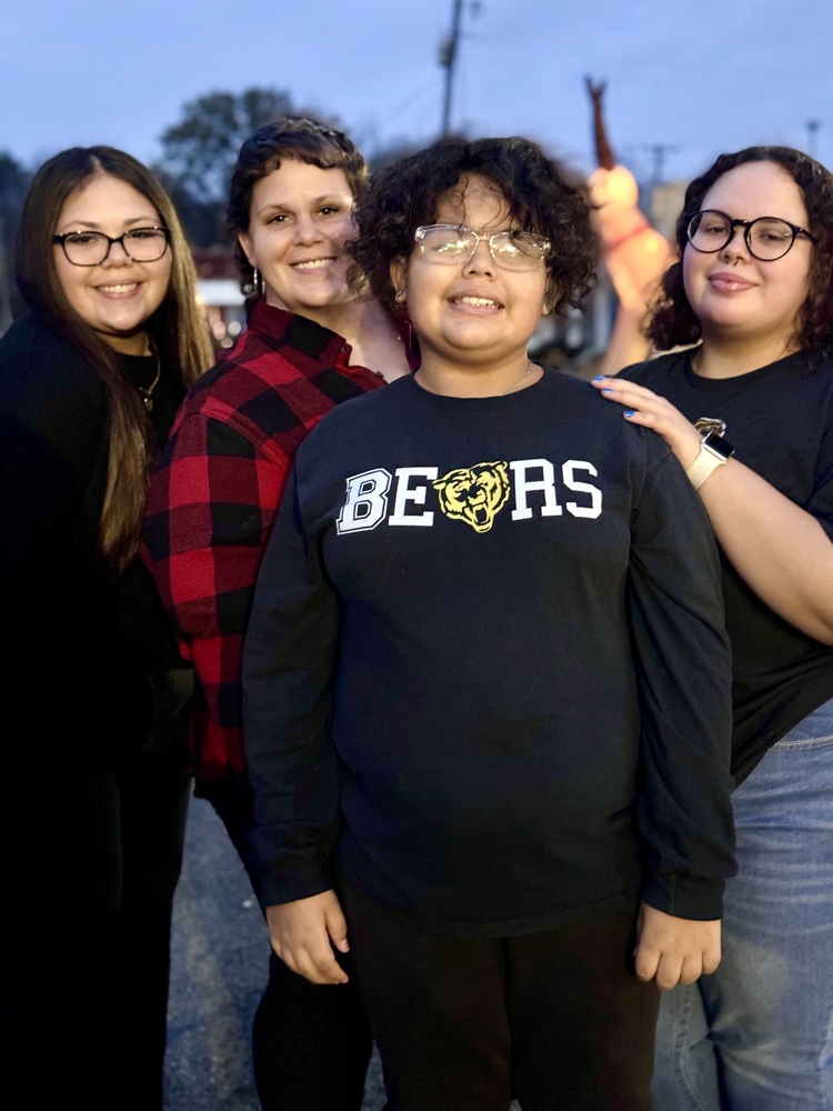 a family of three females and a male smiling