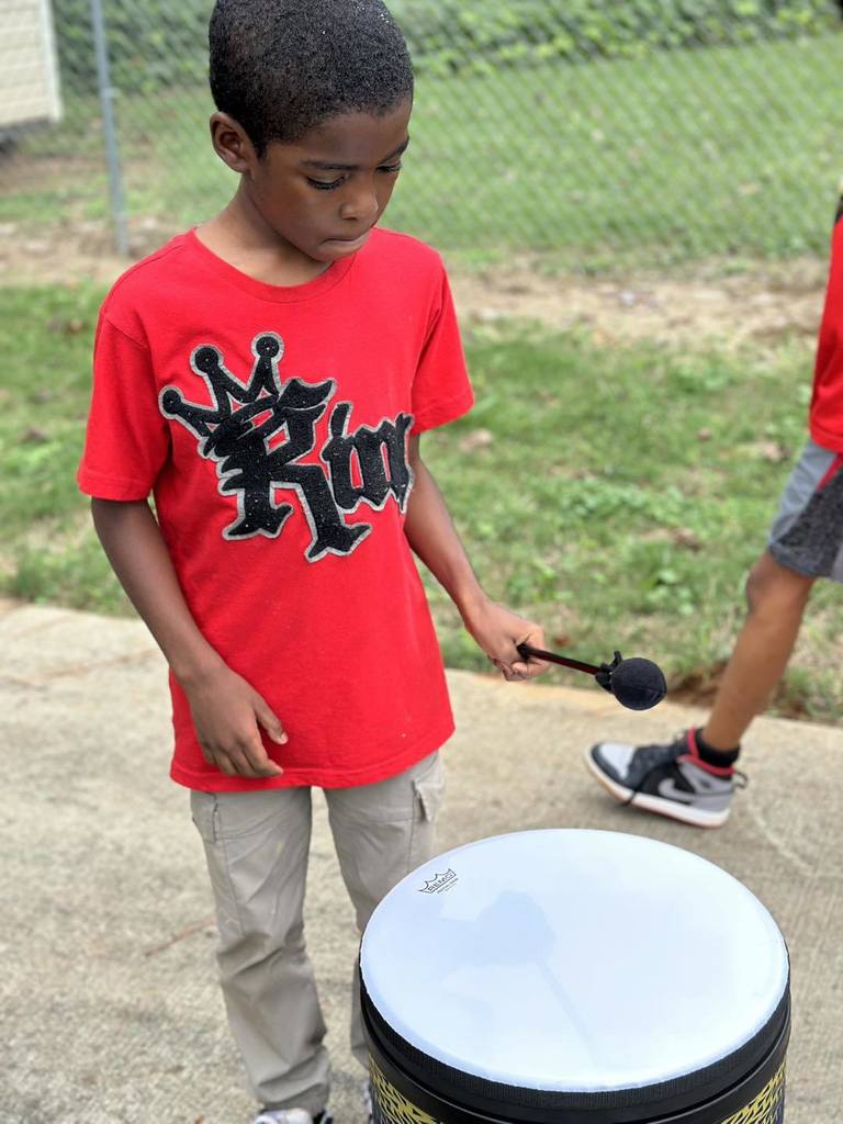A student is playing a drum.