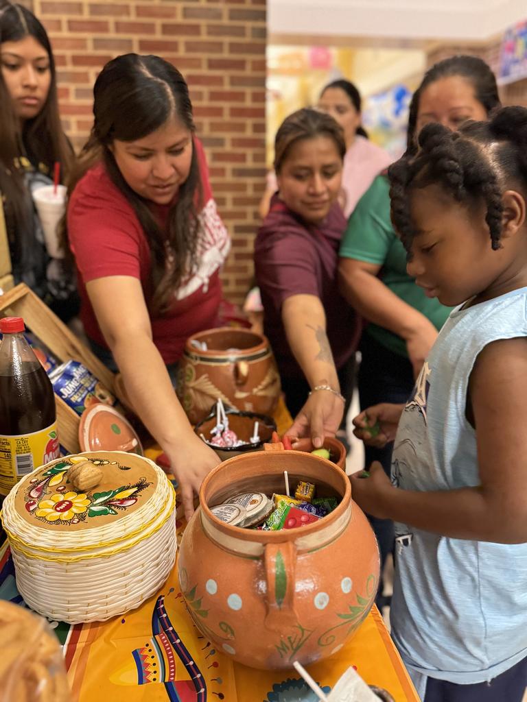 Parents and students getting treats from a table