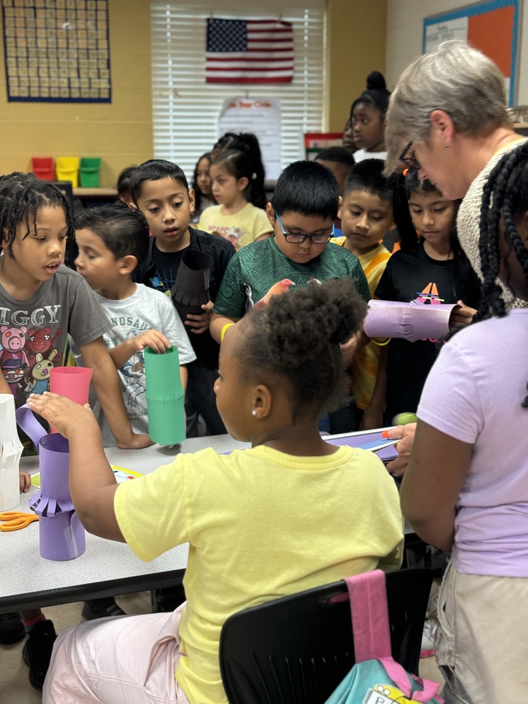 teacher helping students make paper lanterns