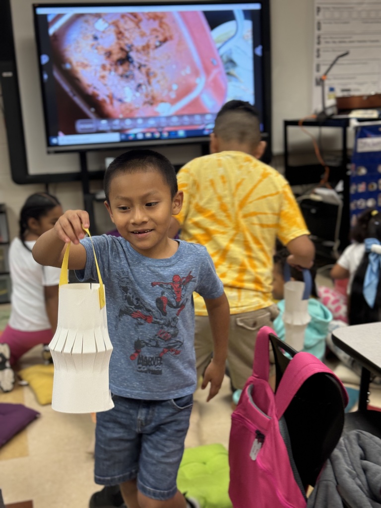 student holding up his paper lantern