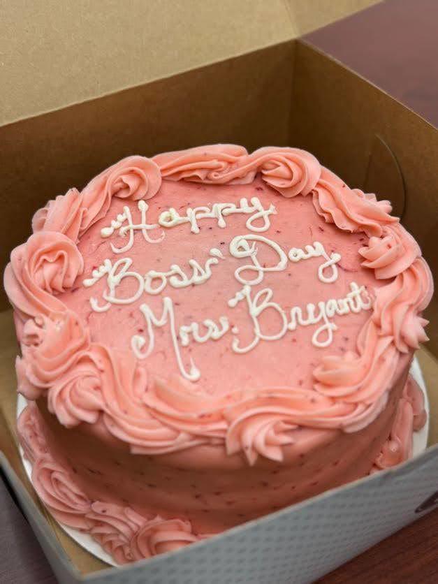 a strawberry cake with pink icing and white words that say Happy Boss' Day Mrs. Bryant