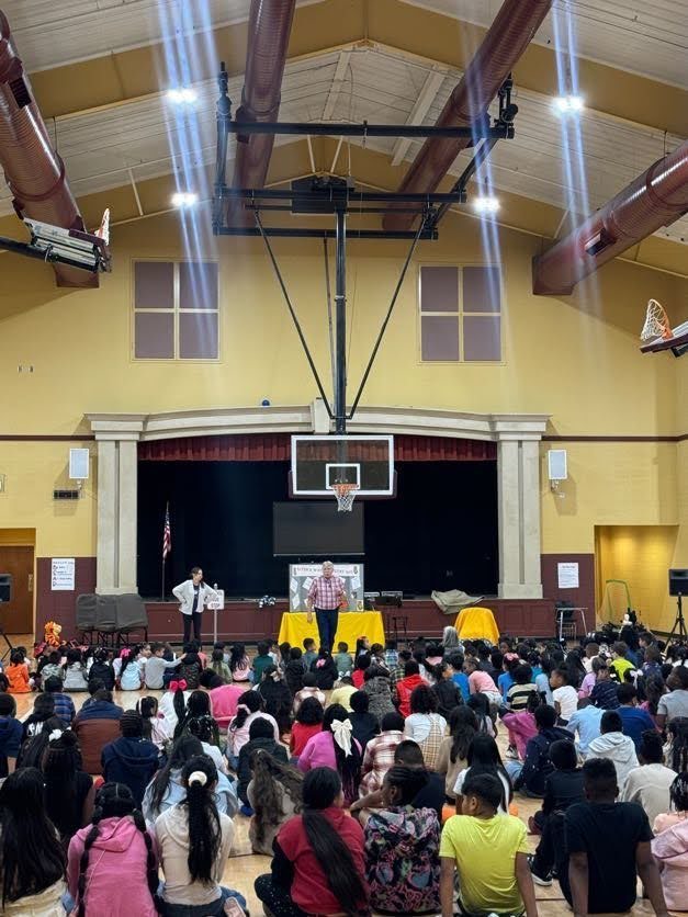 students sitting and facing a stage