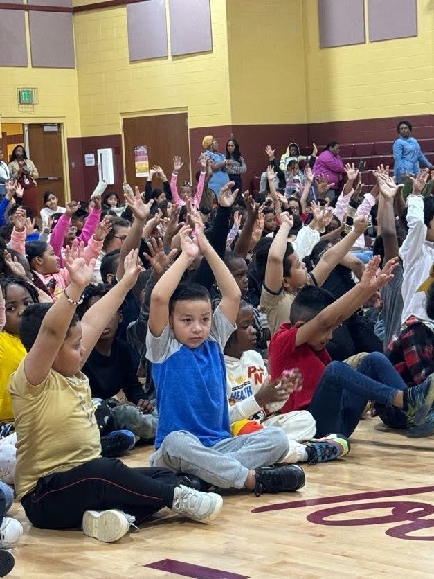 students sitting and raising their hands