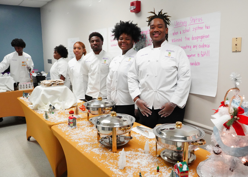 Members of the Hueytown High School culinary arts department wait to serve treats.