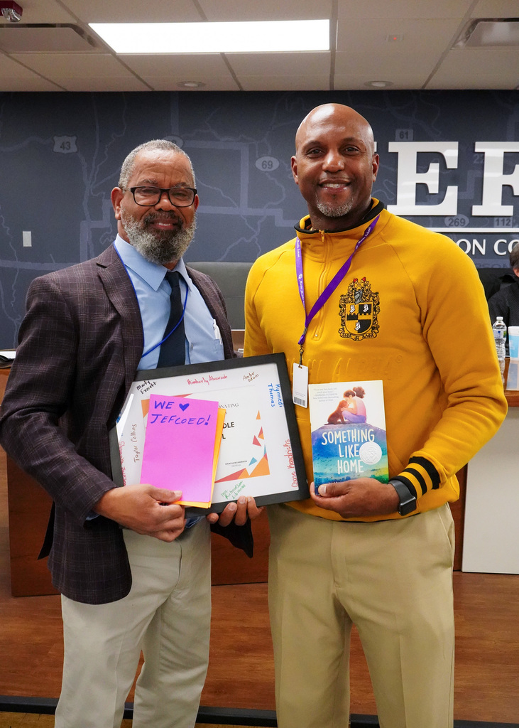 Board Member Walt Curry receives thank you letters from school students during a board meeting.